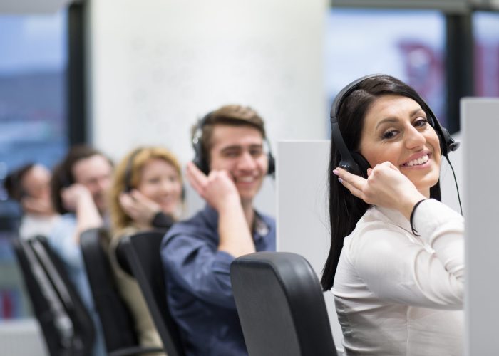 group of young business people with headset working and giving support to customers in a call center office